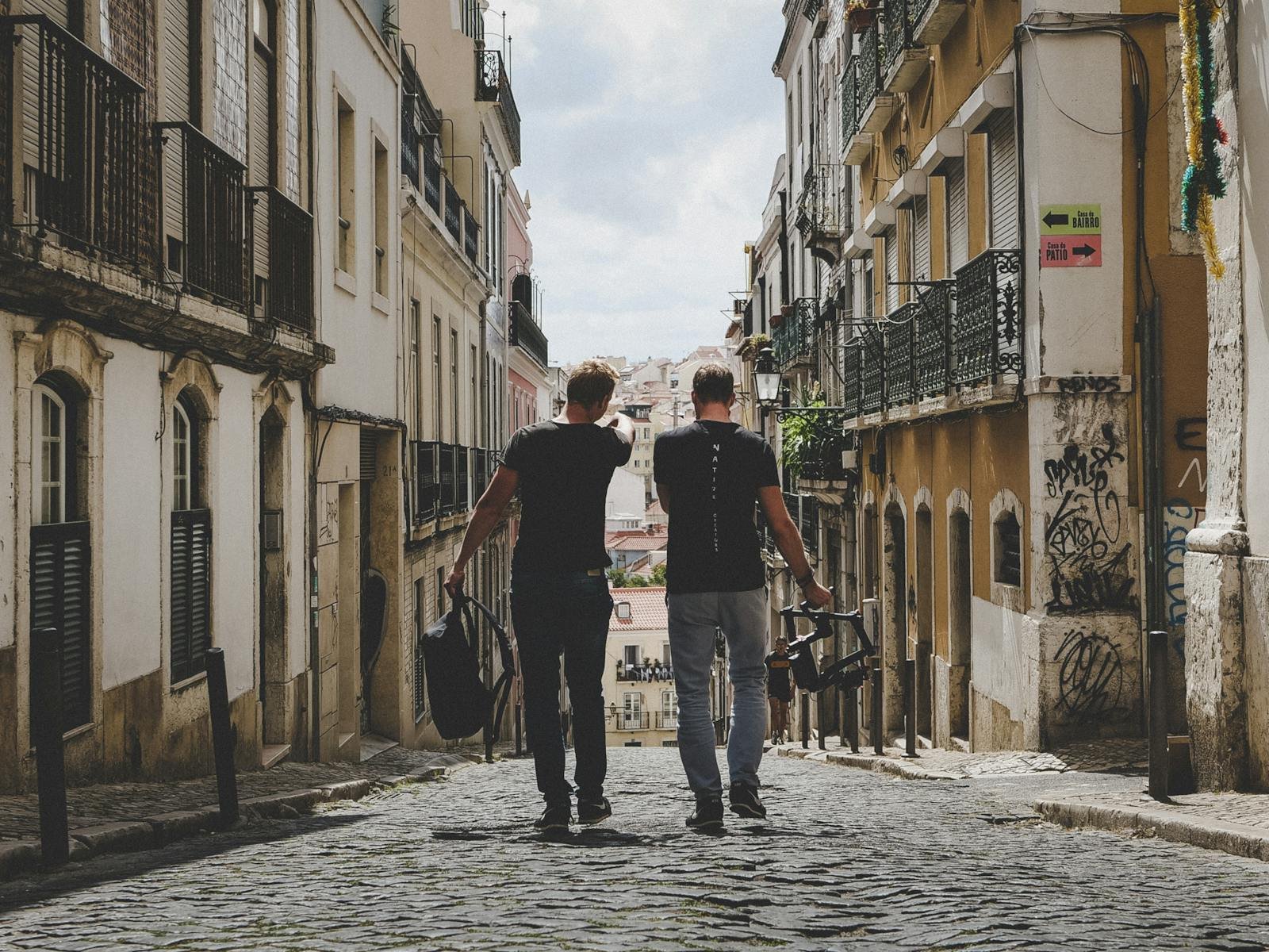 Two friends walking through Lisbon's charming cobblestone streets, capturing the urban vibe.